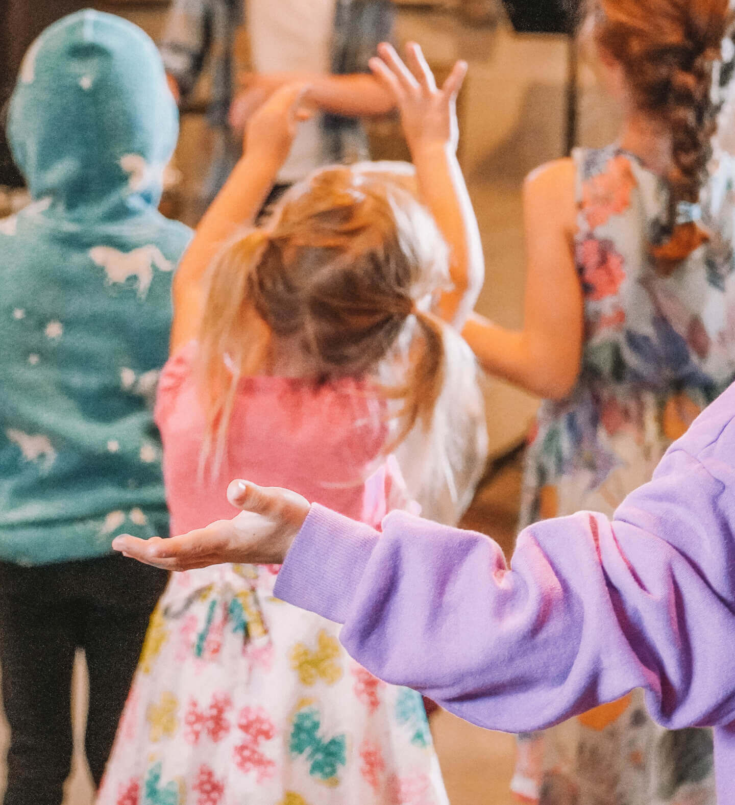 A group of pre-k and kindergarten age kids reaching up during a Sunday school service