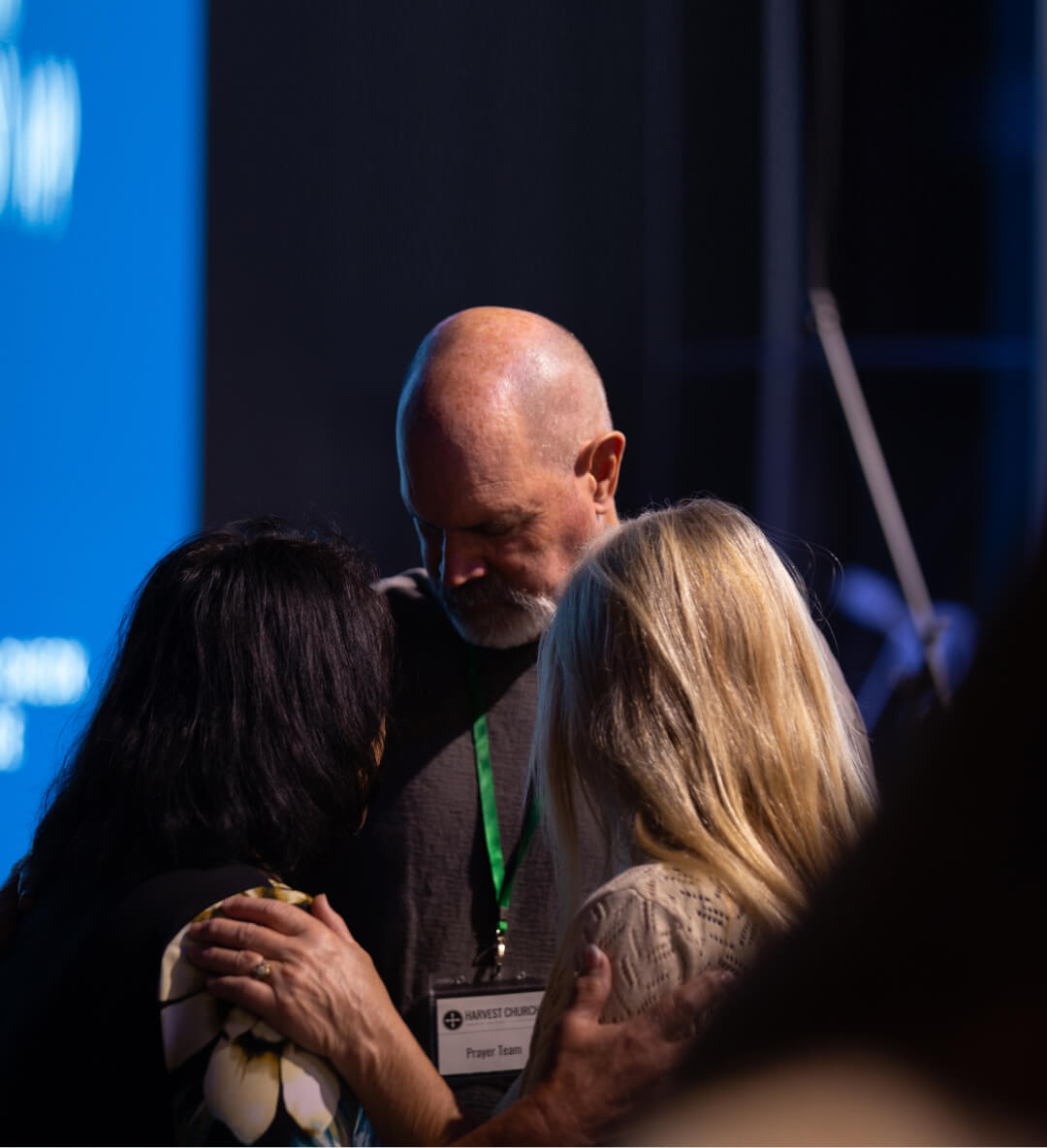Image of prayer happening during a Harvest Church worship service