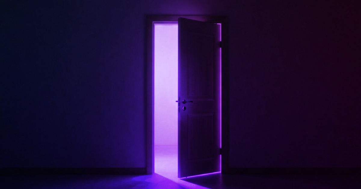 A door slightly open with a purple light coming from the doorway