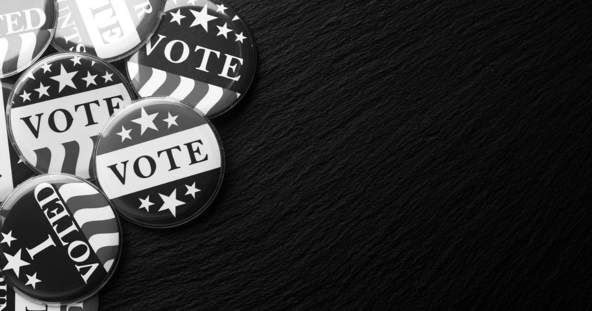 stack of vote stickers and buttons