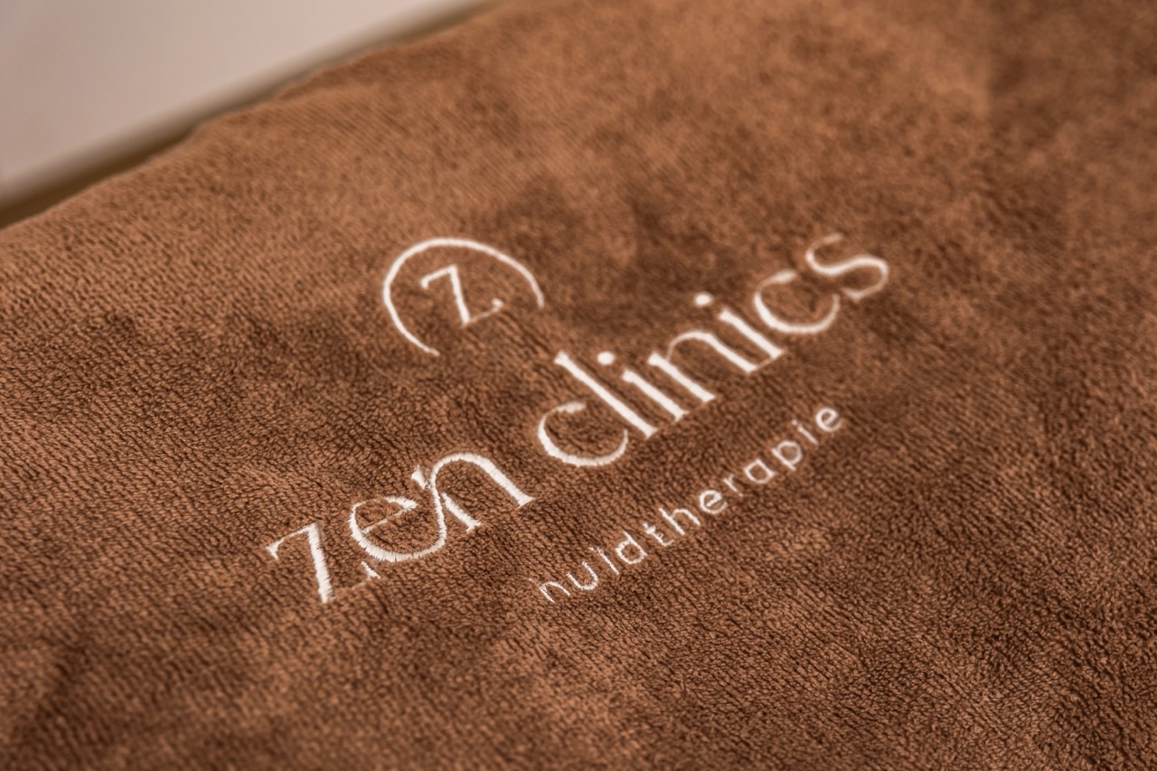 Handdoek met het logo van Zen Clinics in de behandelkamer in Amstelveen
