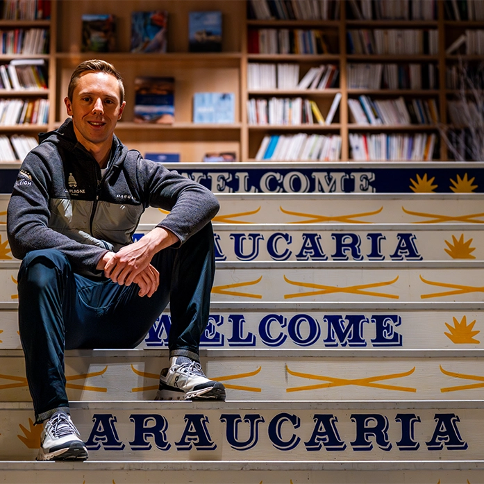 Lucas Defayet assis sur les marches du hall de l'hôtel Araucaria