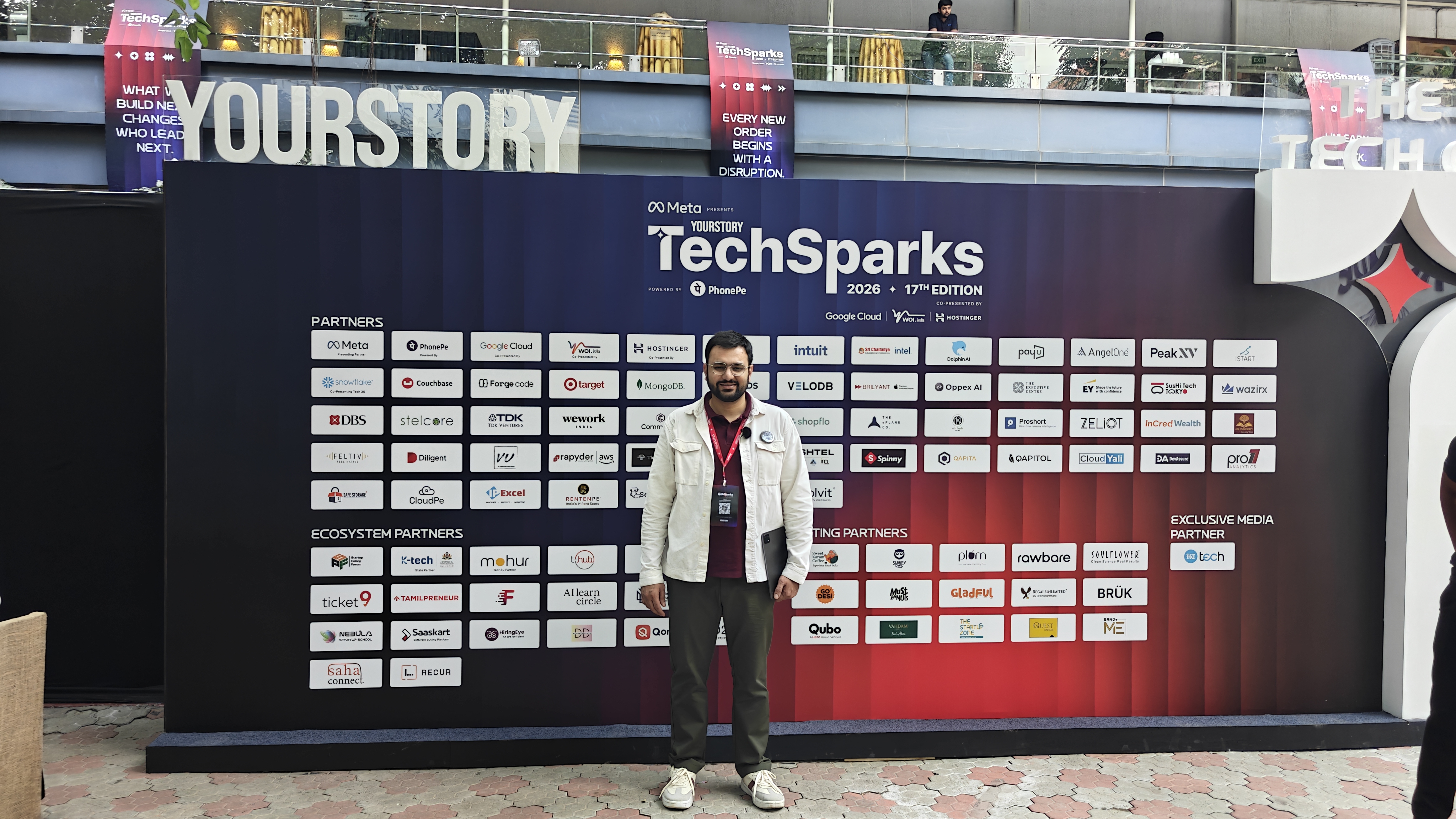 Nishant from Flowtrix in front of the TechSparks 2026 partner wall in Bengaluru