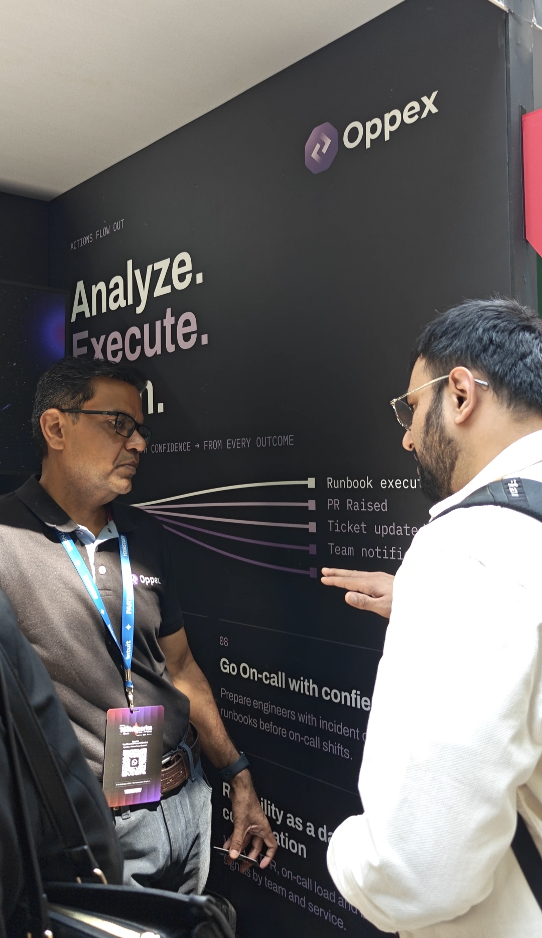 An Oppex AI team member walking Nishant from Flowtrix through the incident workflow wall at TechSparks 2026