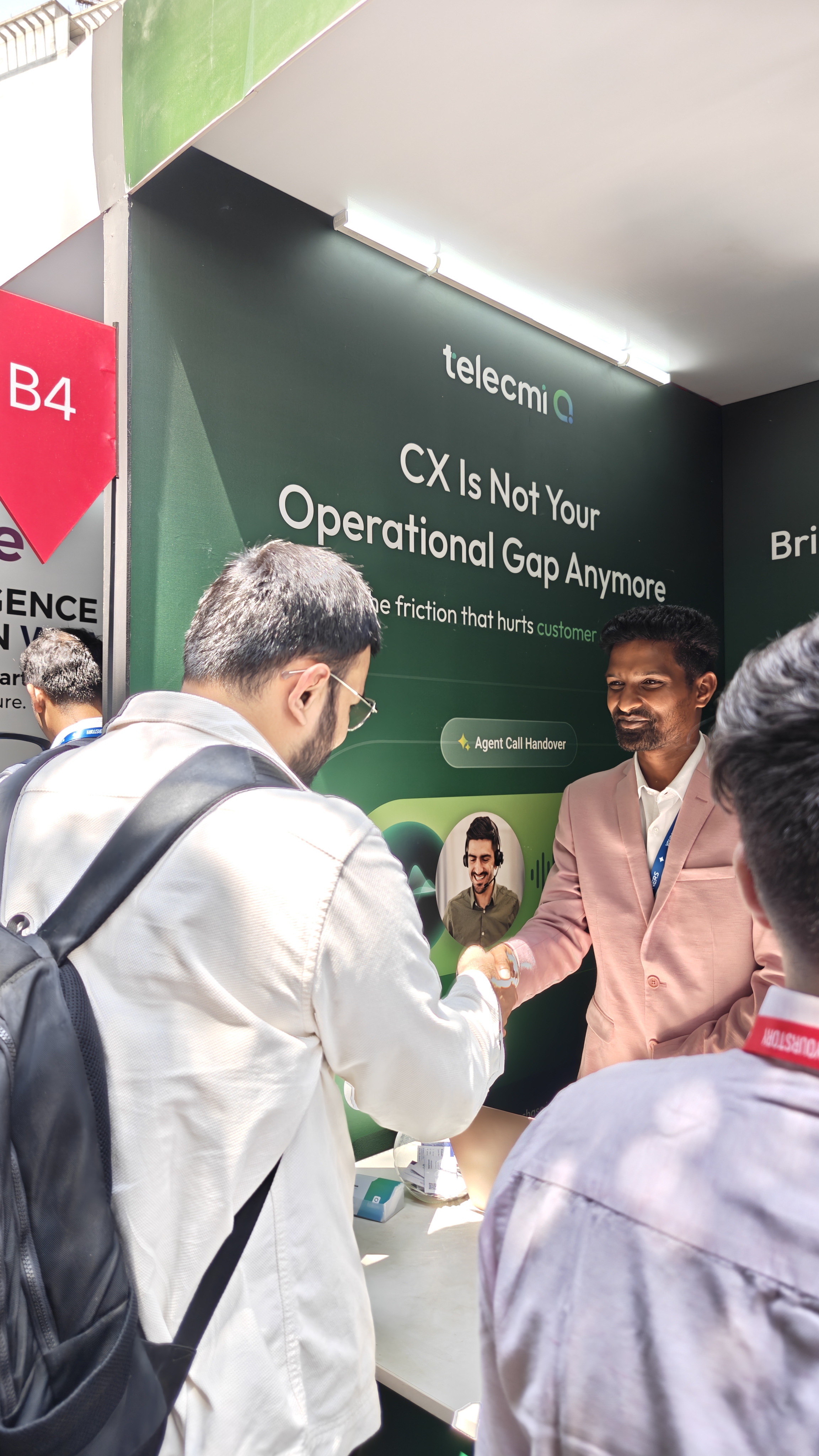 Nishant from Flowtrix shaking hands with a TeleCMI team member at their booth at TechSparks 2026