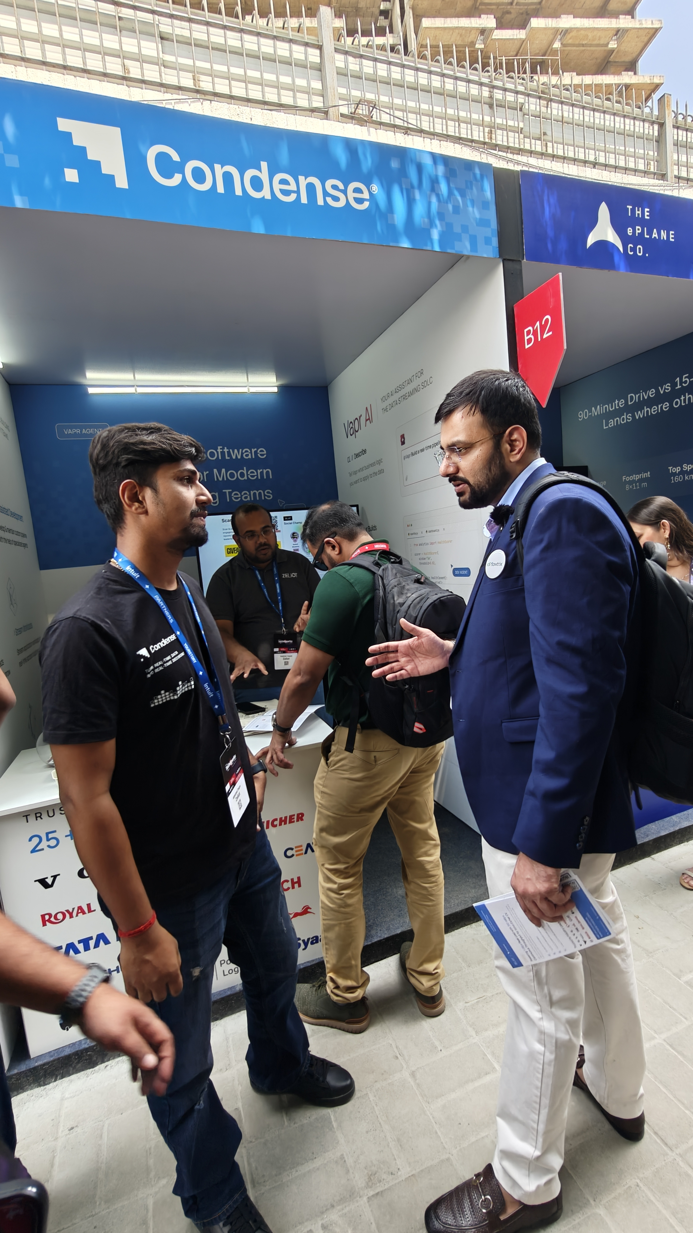Nishant from Flowtrix in conversation with a team member at the Condense by Zeliot booth at TechSparks 2026