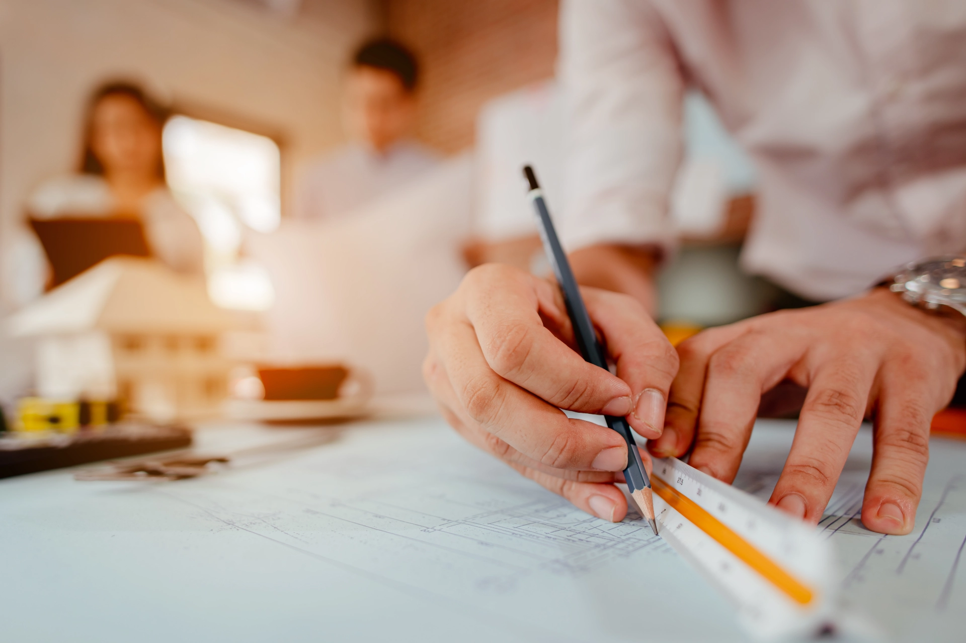 Architect sketching on blueprints with team in background, reflecting HOAI Phase 3 system planning and integration planning.