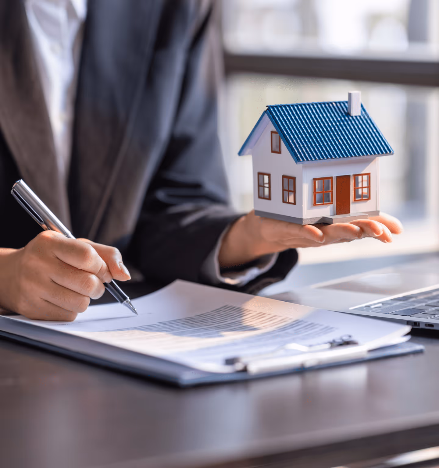 Mortgage broker holding a house.