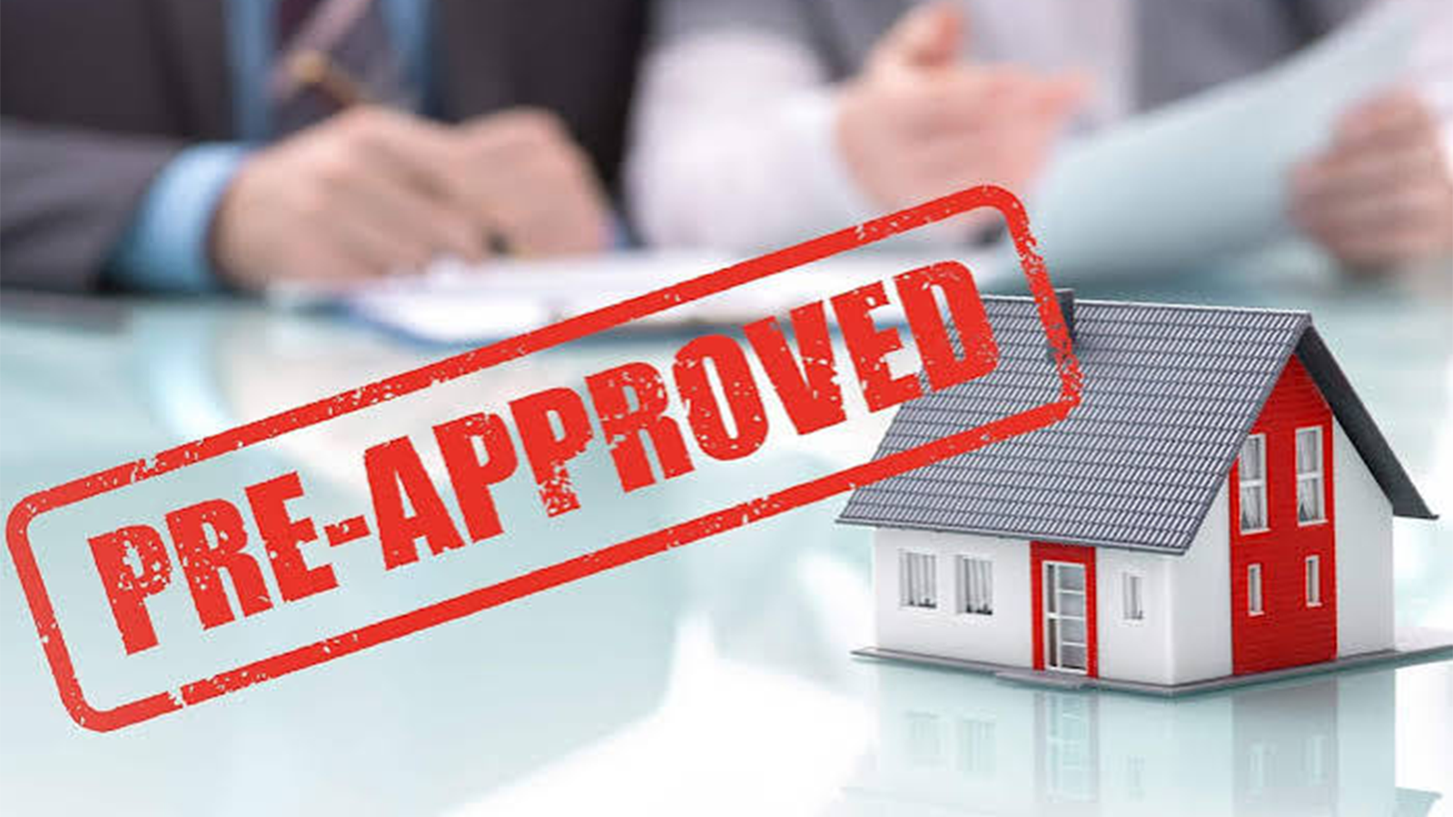 Model house with red accents on a table and a red pre-approved stamp overlay.
