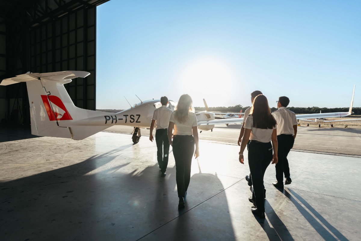 Sevenair Academy cadets walk towards a Diamond DA42 aircraft leaving the hangar