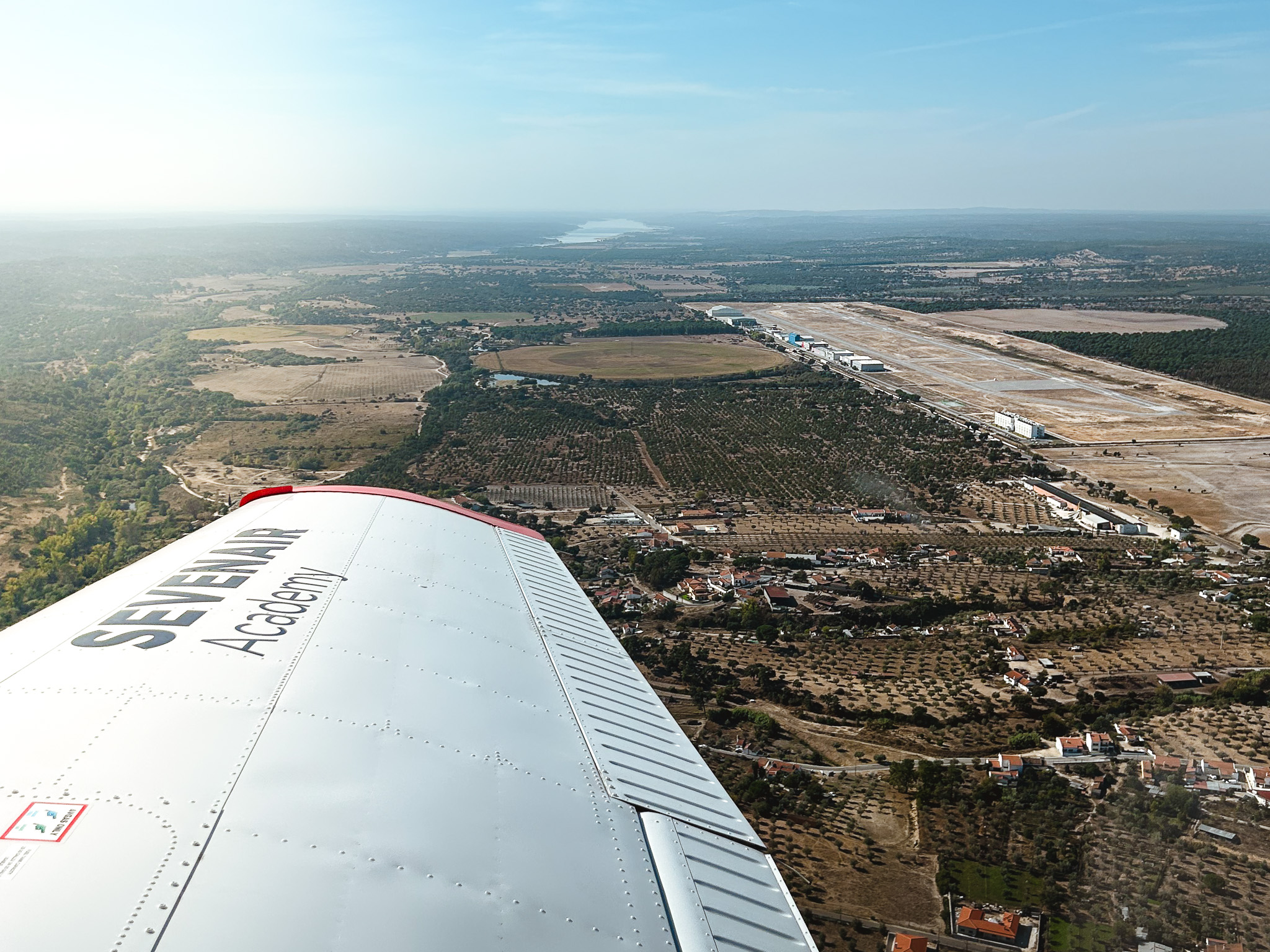 View over the wing of a Sevenair Academy Piper PA-28 in flight over Ponte de Sor