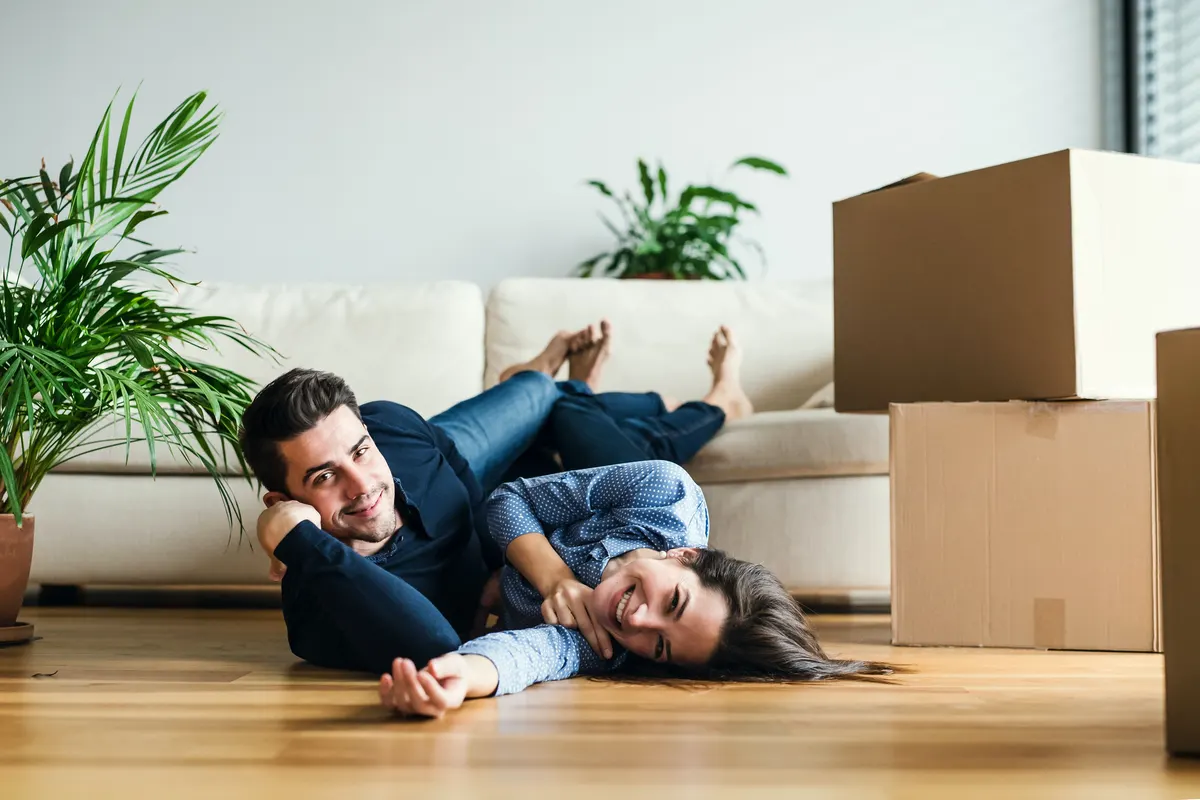 A couple laying on the floor in a living room.