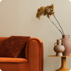 Orange velvet sofa with a dark brown cushion next to a side table holding two brown vases with dried flowers.