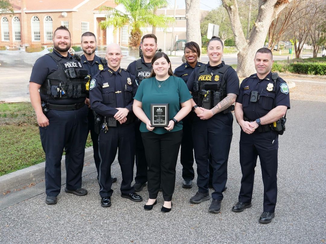 Pinellas Park Police Department officers and staff standing outside police headquarters with an award plaque