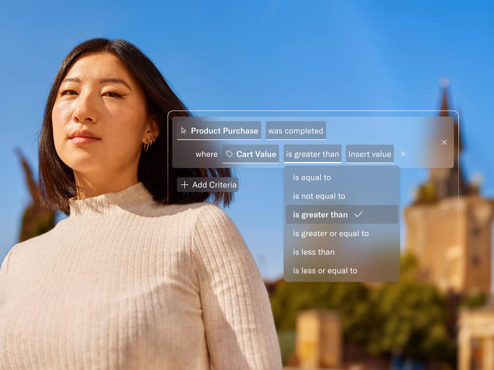A woman stands confidently outdoors in a light beige top with a castle-like structure blurred in the background under a bright blue sky. A transparent UI overlay displays a dynamic filter-building tool, showing “Product Purchase was completed where Cart Value is greater than...” with a dropdown for conditions, visually representing real-time audience segmentation or rules-based personalization.