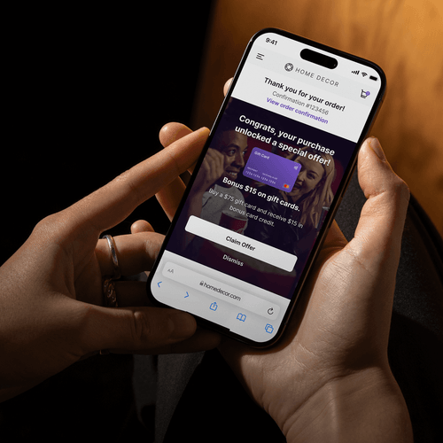 Person holding a smartphone displaying a Home Decor order confirmation and special offer for a $15 bonus on gift cards.
