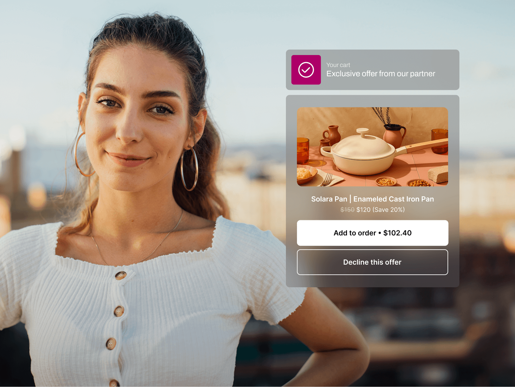 A confident young woman with long, wavy hair tied back, hoop earrings, and a white ribbed top stands outside at sunset, smiling at the camera. Next to her is a semi-transparent pop-up ad overlay for a kitchen product: a white enameled cast iron pan by Solara Pan, originally priced at $150, now discounted to $120 with an option to add it to an order for $102.40. The ad includes a photo of the pan on a table with warm-toned dishes and drinkware, emphasizing a cozy, earthy aesthetic.