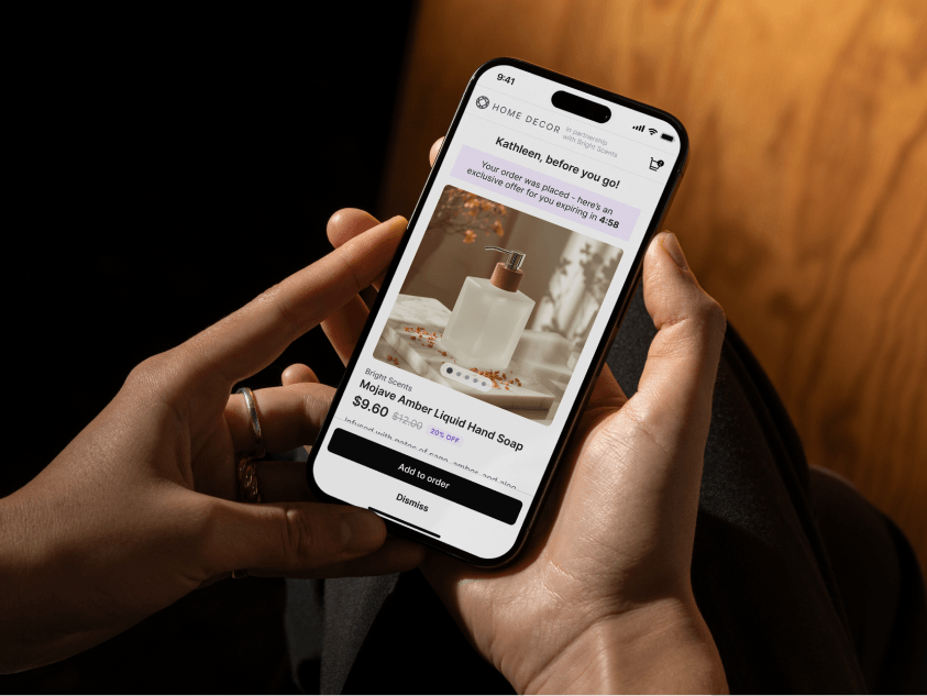 Smartphone screen showing a Home Decor app with a limited-time offer for Mojave Amber Liquid Hand Soap priced at $9.60, with options to add to order or dismiss.