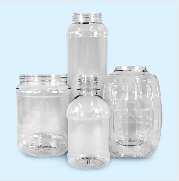 Collection of clear plastic bottles and jars in multiple shapes and sizes for packaging applications.