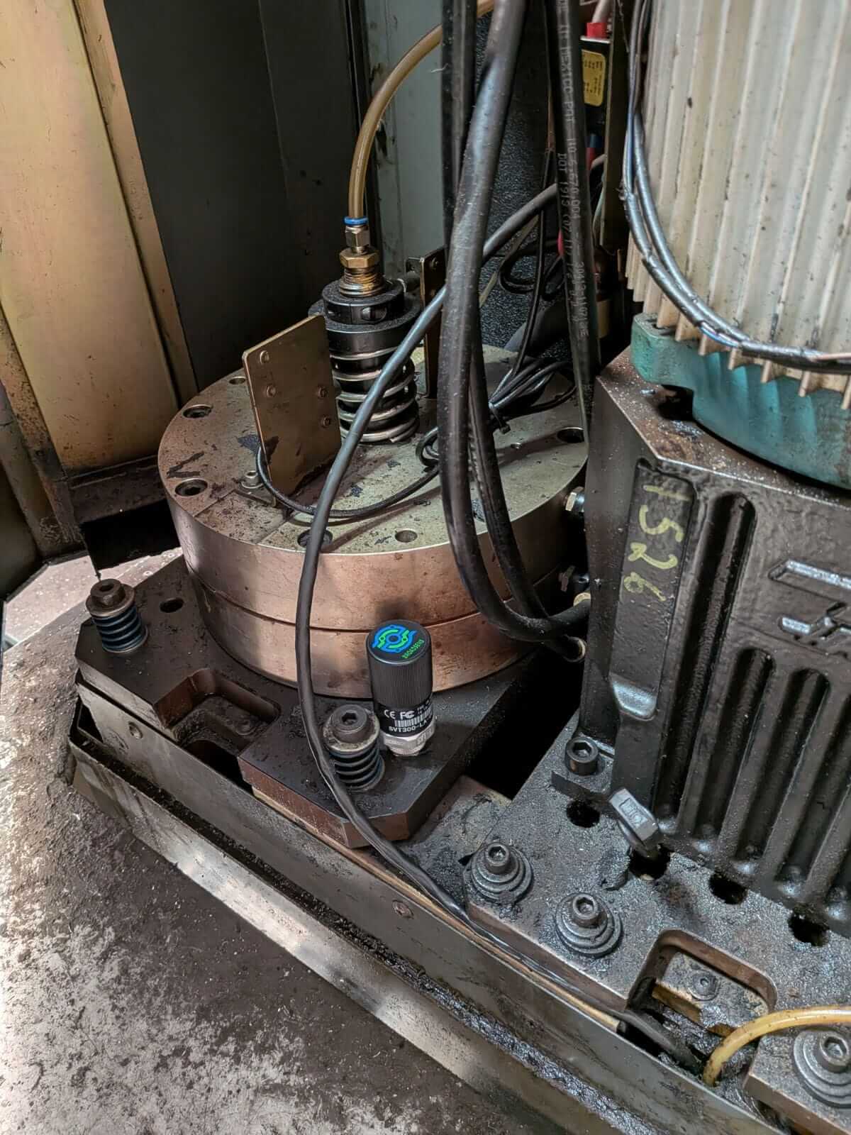 SensFlo sensor installed beside the motor and mechanical assembly of CNC machining equipment for machine monitoring.