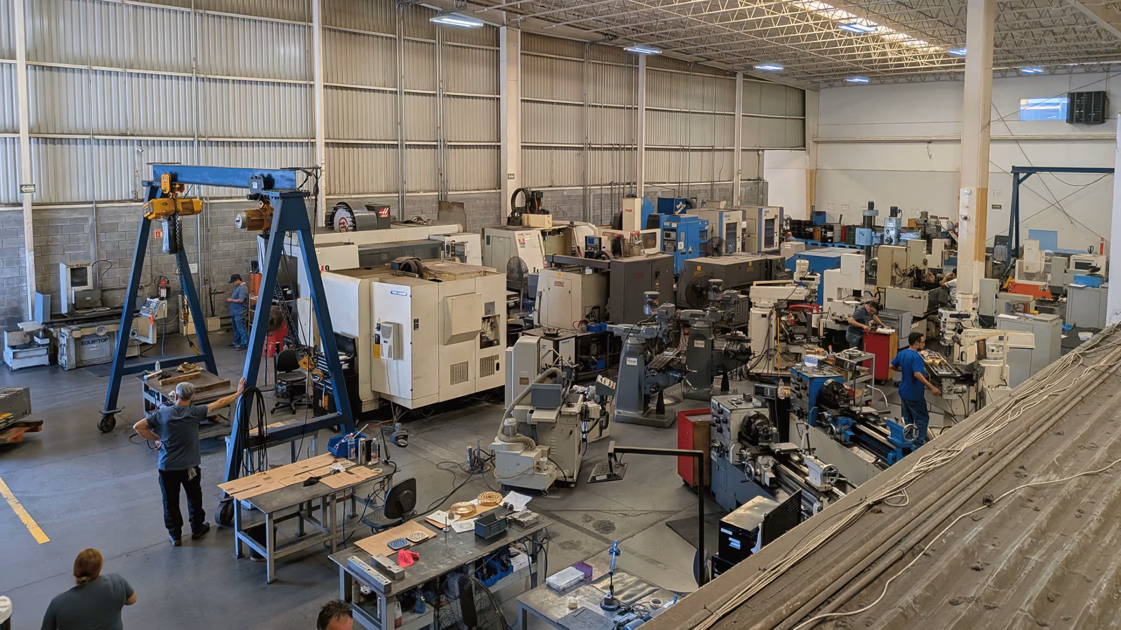 Machine shop floor with legacy CNC mills, lathes, machining equipment, and operators in production.