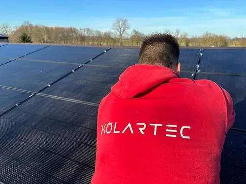 Mitarbeiter von Xolartec betrachtet Solaranlage auf dem Dach