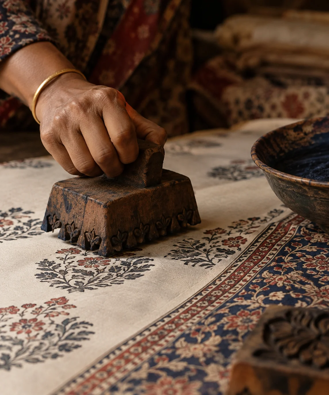Artisan performing traditional hand-block printing on textile, a heritage craft revived by Indian fashion designer Ritu Kumar