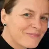 Nahaufnahme einer lächelnden Frau mittleren Alters mit heller Haut und kurzen Haaren.