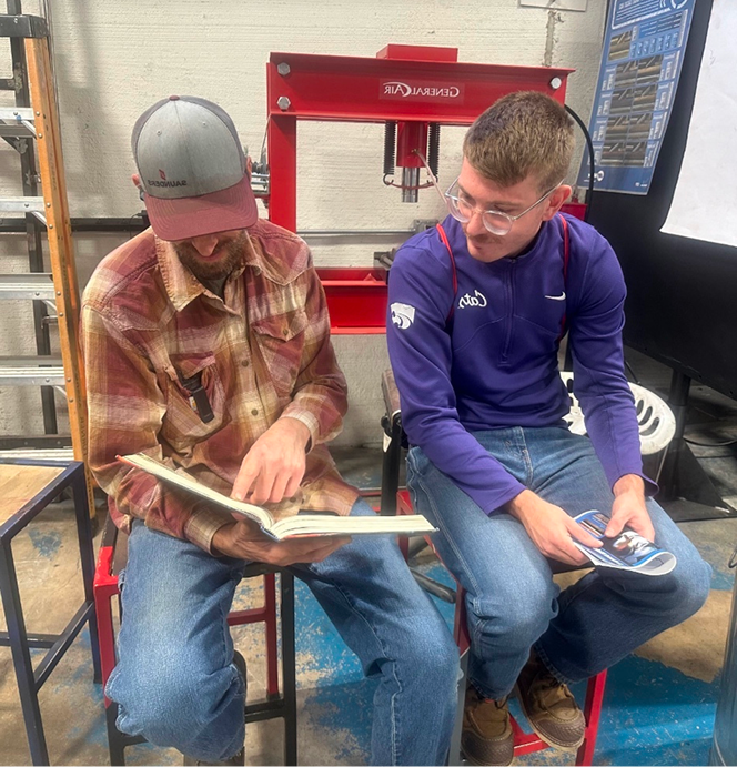 Two welding students looking over their work