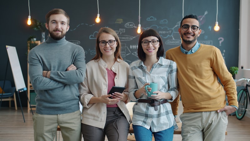 Four diverse colleagues standing together in an office