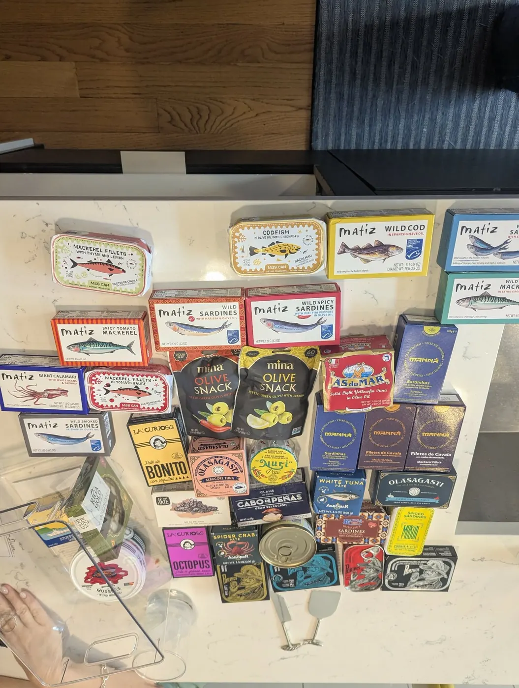 A lineup of tinned fish laid out on a counter before a tasting party
