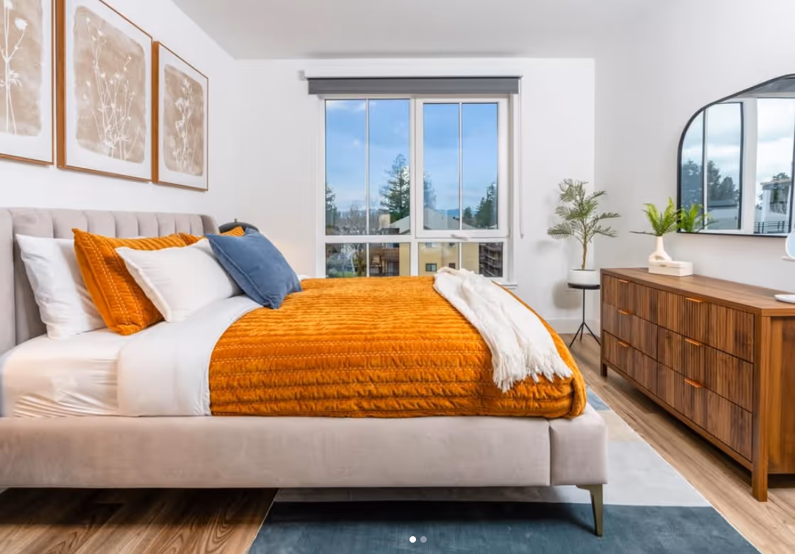 Bedroom with large windows, vanity and a rug