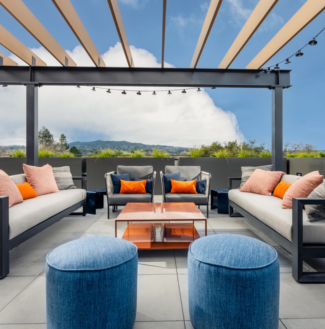 Outdoor lounge area with seating and blue ottamans