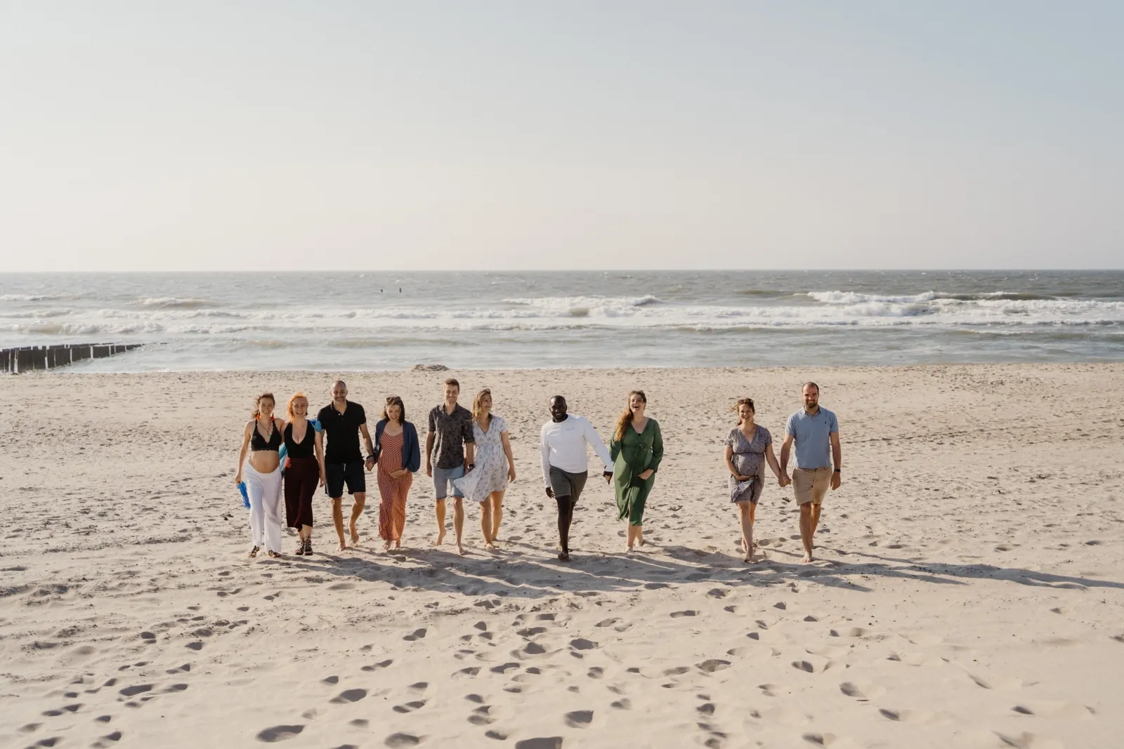 Group walking on the beach at a Mamamoon pregnancy retreat