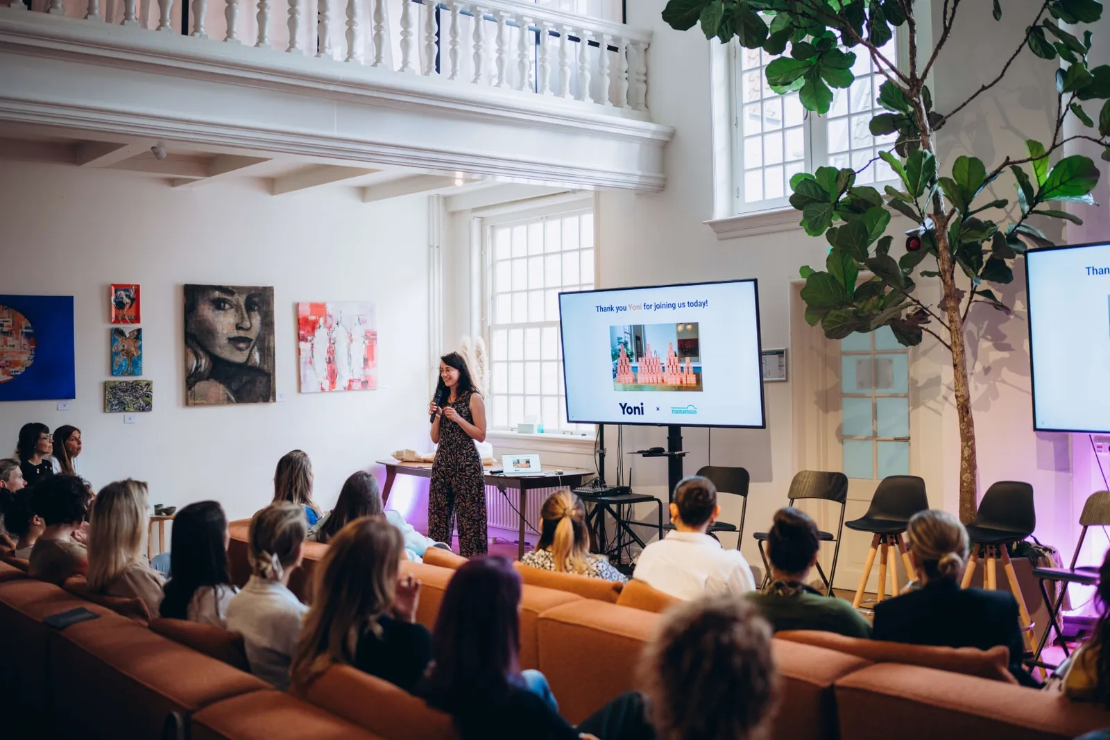 Speaker presenting to a seated audience at a Mamamoon event