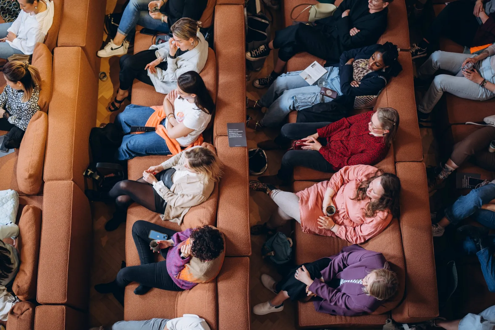 Audience seated on sofas at a Mamamoon event, seen from above