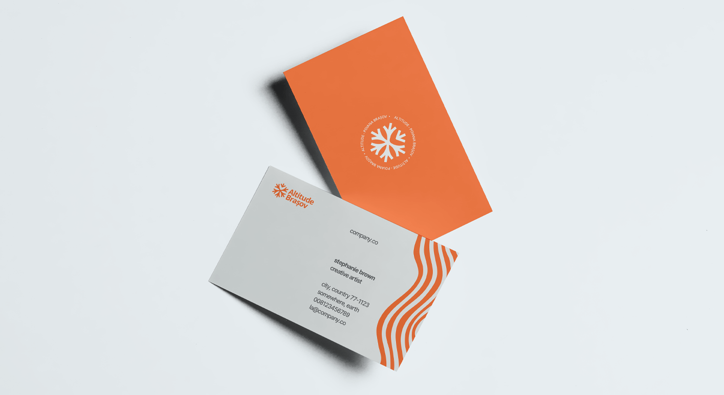Two business cards on a white surface, one orange with a white snowflake logo and the text 'Altitude Romania Brasov,' the other white with orange wave patterns and contact details for Stephanie Brown, creative artist.
