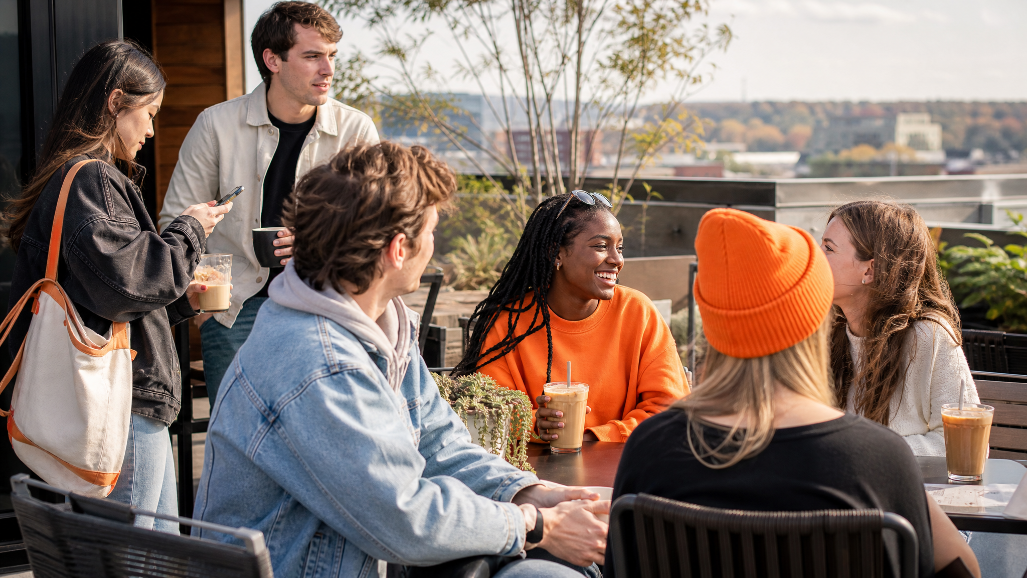 College students laughing together at an outdoor coffee table