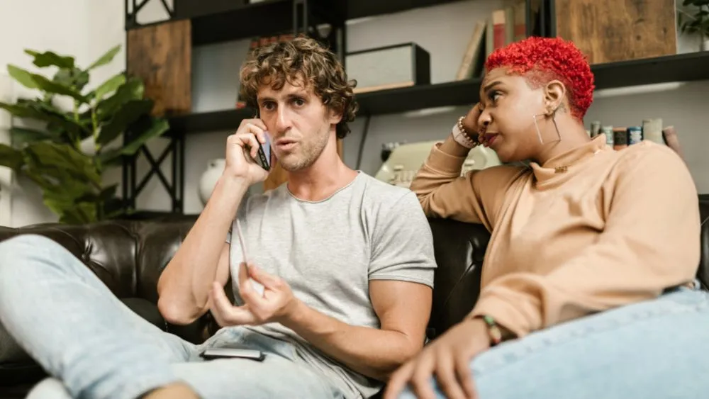 Bezorgd stel op de bank aan de telefoon