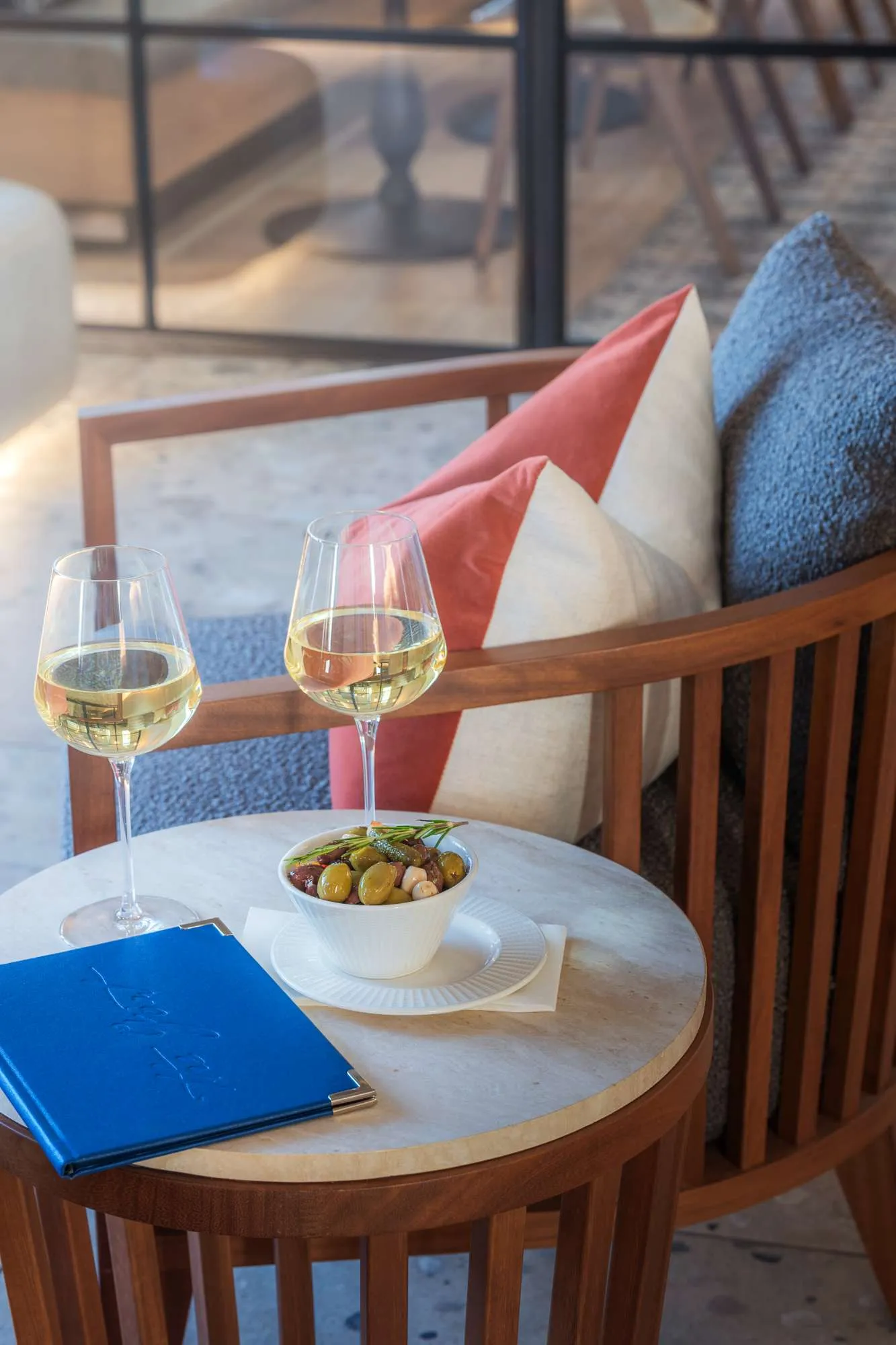 Two glasses of white wine and a snack on a table in the bar at The Goat, Llandudno