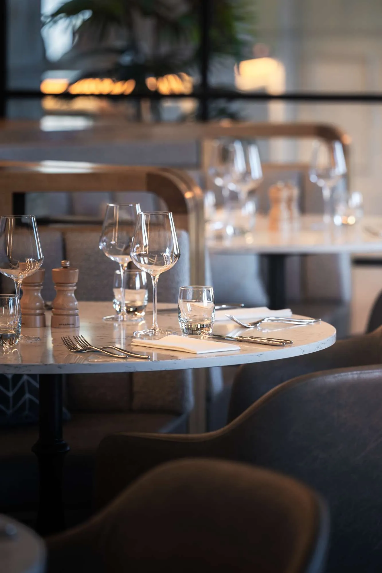 Tables laid with wine glasses in the dining room at The Goat, Llandudno