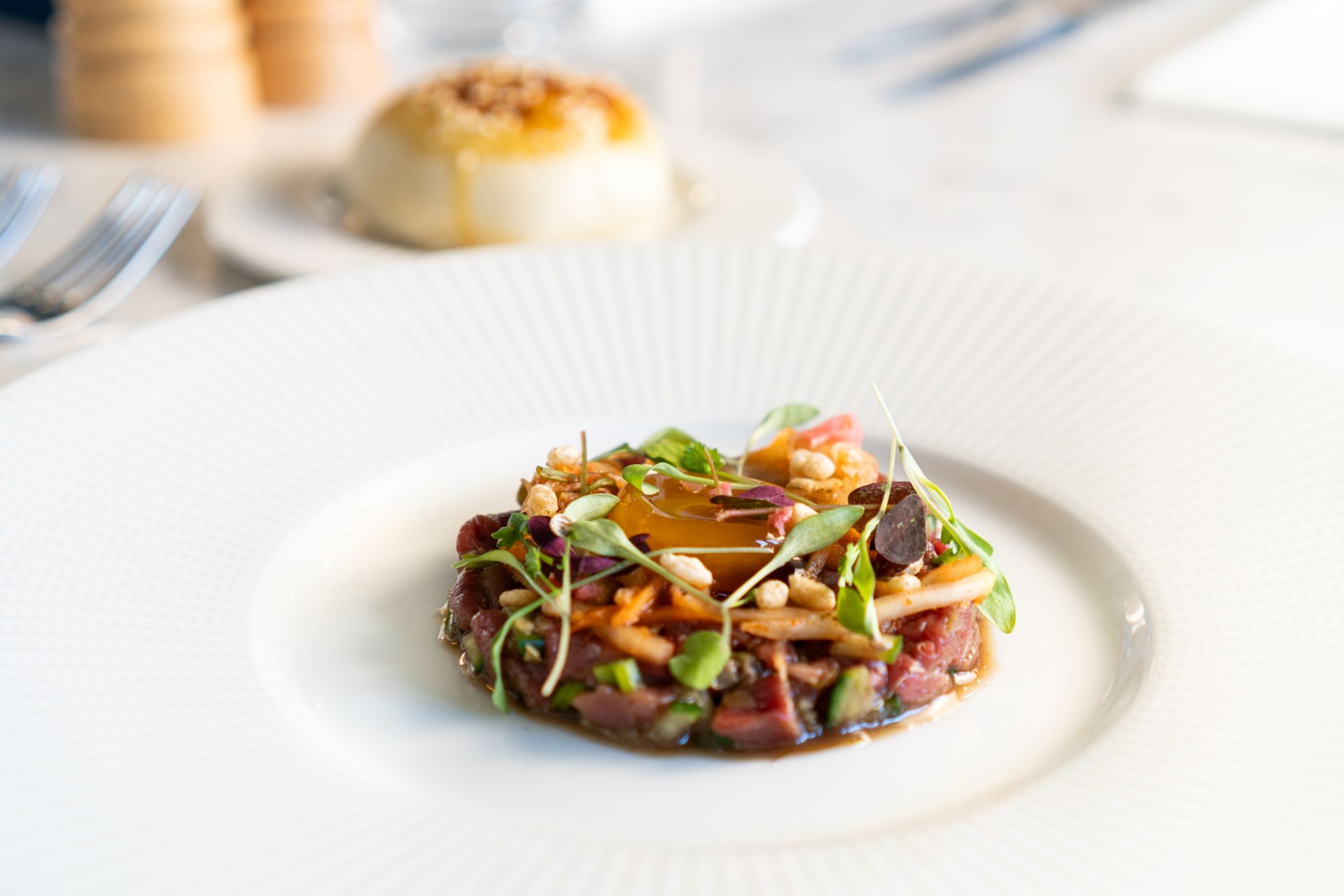 Image of parsnip risotto with a glass of wine on a marble table
