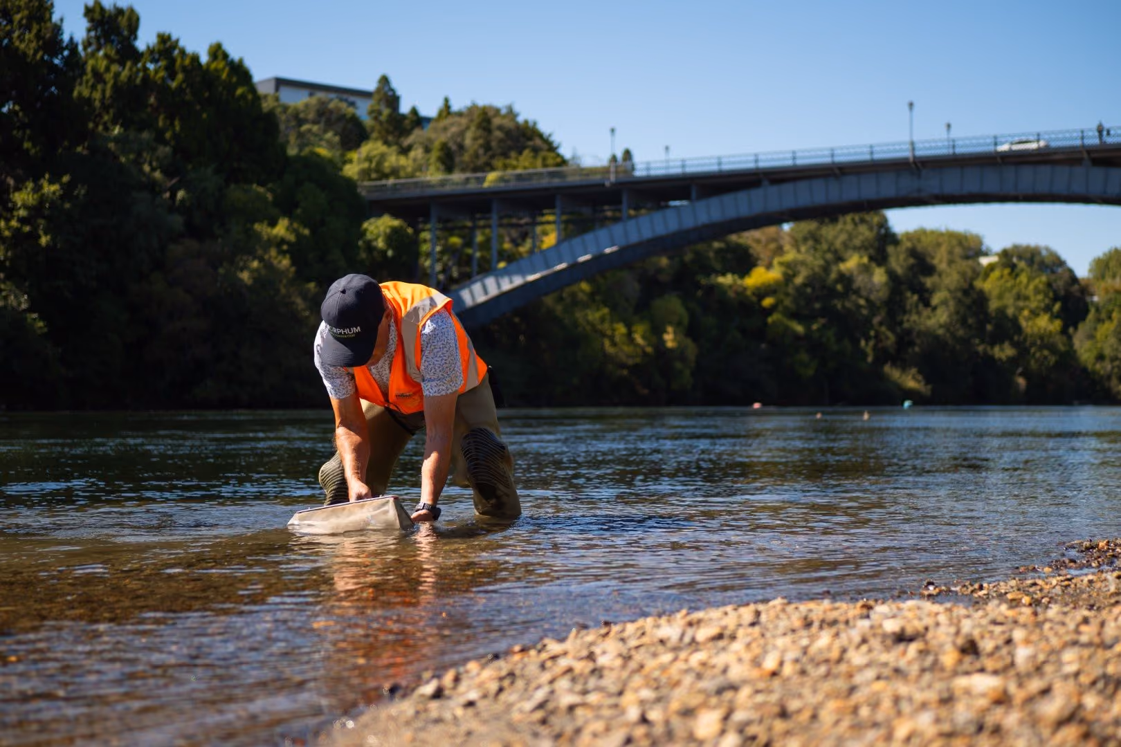 Environmental scientist and ecologist from New Zealand testing the water quality of a freshwater river for an environmental management assessment