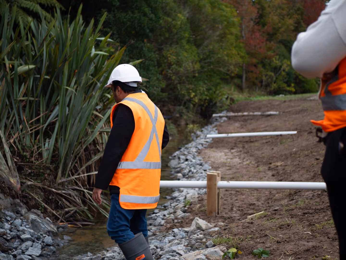 Two environmental engineers working on stream stabilisation project in New Zealand to prepare the local community for potential flooding events and land slips