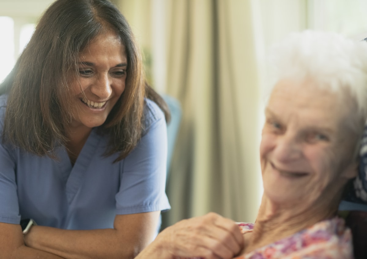 Compassionate nurse sharing a warm moment with an elderly patient in a comfortable care setting