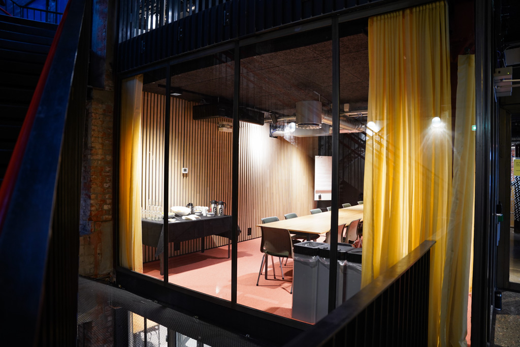 Møterom 300 på Sentralen. Møterommet har store vinduer med utsikt ut mot trappeløpet og lyse gardier.