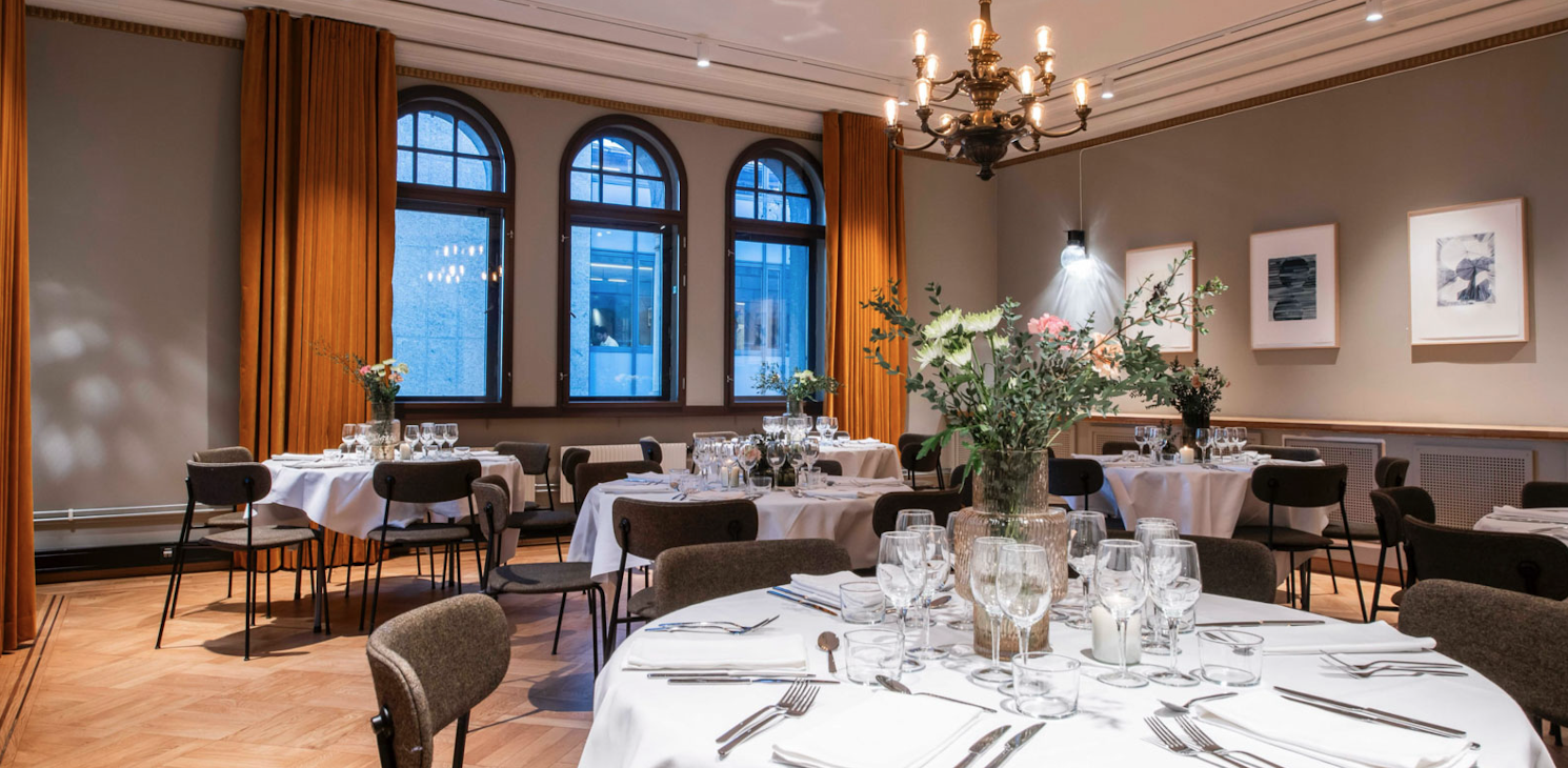 Bord som er dekket med blomster, bestikk og meny.