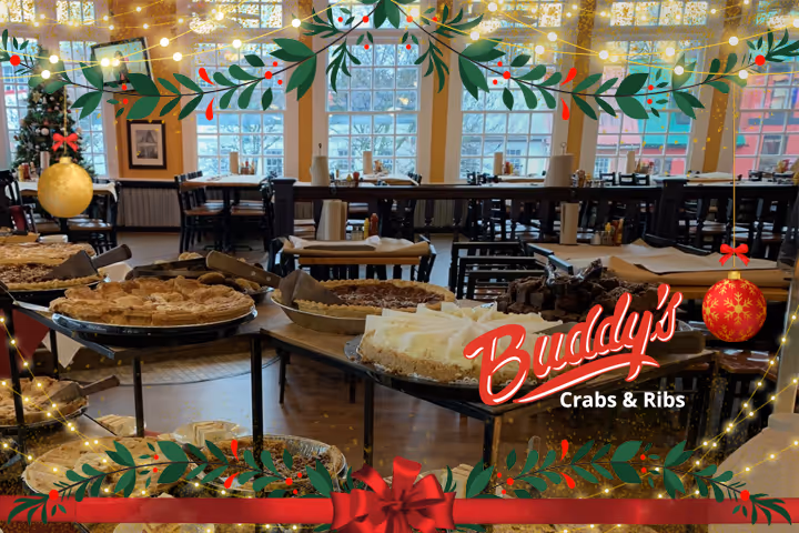 Guests enjoying seafood and waterfront views at Buddy’s Crabs & Ribs in Downtown Annapolis during Memorial Day Weekend, with patriotic decorations and Naval Academy families celebrating nearby.