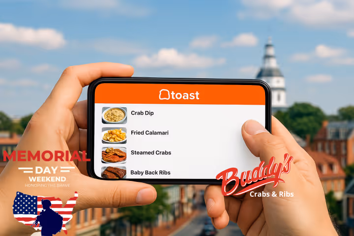 Guests enjoying seafood and waterfront views at Buddy’s Crabs & Ribs in Downtown Annapolis during Memorial Day Weekend, with patriotic decorations and Naval Academy families celebrating nearby.