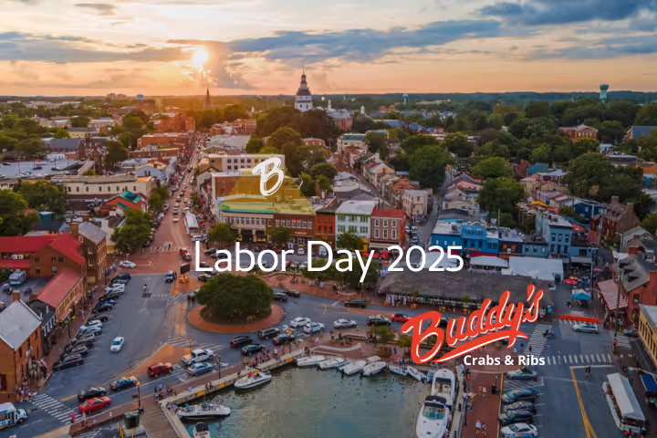 Guests enjoying seafood and waterfront views at Buddy’s Crabs & Ribs in Downtown Annapolis during Memorial Day Weekend, with patriotic decorations and Naval Academy families celebrating nearby.